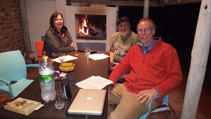 A group of people seated around a table with a laptop, documents, and food. - Room-boutique Self Catering Guesthouse 4 (Johannesburg)