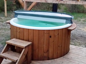 A wooden hot tub with a built-in seat and a small wooden step for access. - 5 Star Holiday Home in Bording (Bording)