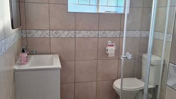 A bathroom with a shower, toilet, and sink.
