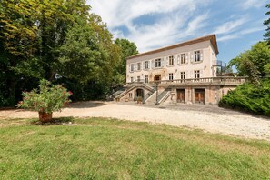 A large, historic building with a symmetrical facade, multiple windows, and a central entrance. - Spacious Duplex Retreat for 8 (Grospierres)