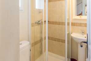A bathroom with a glass-enclosed shower, a toilet, and a sink. - Spacious Duplex Retreat for 8 (Grospierres)