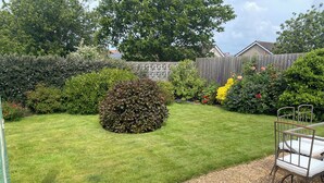 A well-maintained garden with a lawn, a gravel path, and a metal bench. - Luxury annex, close to Newquay beaches, town, and amenities! Peaceful spot! (Newquay)