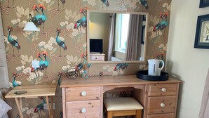 A wooden desk with drawers, a mirror, and a chair in a room with floral wallpaper. - Luxury annex, close to Newquay beaches, town, and amenities! Peaceful spot! (Newquay)