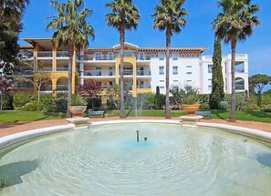 Ein Hotel mit Pool, Palmen und blauem Himmel.
