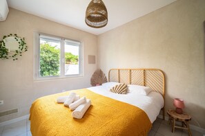 A bedroom with a bed, a window, a bedside lamp, and a wall-mounted mirror. - L'Horizon Doré - 500m de la Plage (Saint-Cyprien)