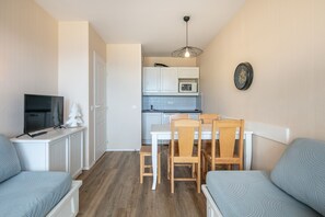 A compact living space with a kitchenette, a dining area, and a seating area. - Le Thabor Caribou - À 650 m des pistes (Valmeinier)