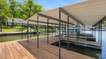 Une jetée en bois dotée d’une zone abritée, d’une rampe pour bateaux et offrant une vue sur une marina remplie de bateaux.