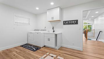 Une buanderie équipée d’un lave-linge, d’un sèche-linge et d’une pancarte indiquant « BUANDERIE ».