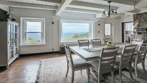 Un comedor con una mesa grande, sillas y vistas al exterior.