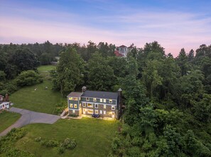 A two-story house with a stone facade, surrounded by dense forest. - Swannanoa Guest House: Stunnning Mountain Views (Afton)