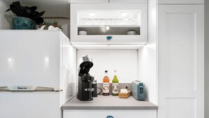 Eine Küche mit Kaffeemaschine, zwei Flaschen Monin Sirup, Toaster und Mikrowelle.