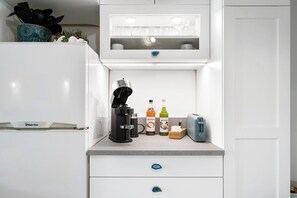 A kitchen with a coffee maker, two bottles of Monin syrup, a toaster, and a microwave.