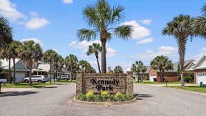 A sign for Kennedy Park surrounded by residential houses and palm trees. - 4BR Foley Home Near OWA and Beaches (Foley)