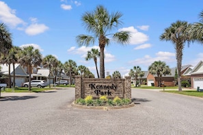 A sign for Kennedy Park surrounded by residential houses and palm trees. - 4BR Foley Home Near OWA and Beaches (Foley)