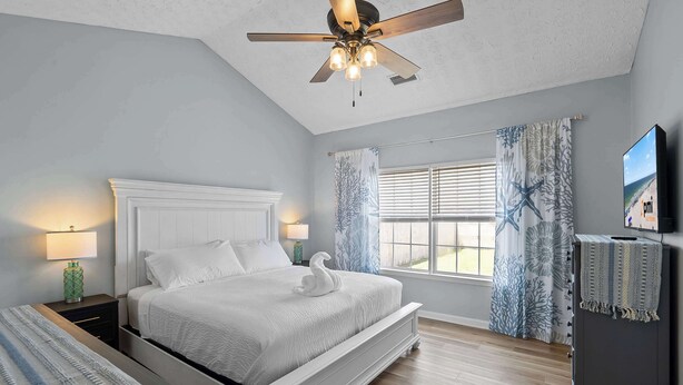A bedroom with a bed, a nightstand, a dresser, a ceiling fan, and a window with curtains. - 4BR Foley Home Near OWA and Beaches (Foley)