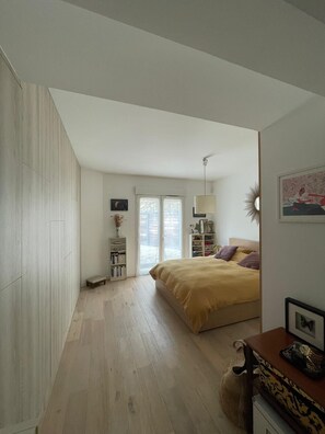 A bedroom with a bed, a bedside table, a lamp, a bookshelf, and a window. - Marseille: sea and garden views at Endoume! (Marseille)