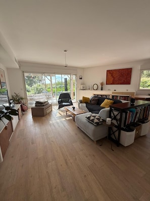 A spacious living room with a sofa, coffee table, and a bookshelf. - Marseille: sea and garden views at Endoume! (Marseille)