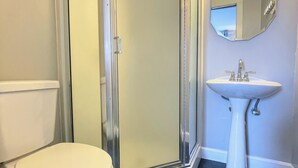 A bathroom with a toilet, a shower enclosure, and a sink. - Walk to Lake & Downtown Chelan! Room #3 (Chelan)