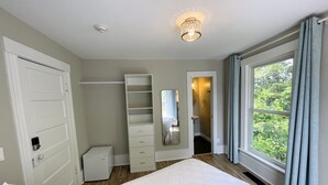 A bedroom with a bed, a wardrobe, a mirror, and a window with curtains. - Walk to Lake & Downtown Chelan! Room #3 (Chelan)