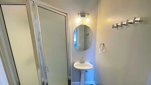 A bathroom with a shower, a sink, a mirror, and a towel rack. - Walk to Lake & Downtown Chelan! Room #3 (Chelan)
