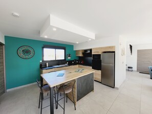 Una cocina moderna con una isla central, un fregadero y un refrigerador.
