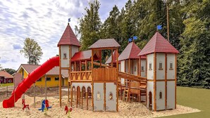 A playground with a red slide and climbing structures. - Ferienhaus mit Whirlpool und Sauna in Bad Bevensen (Bad Bevensen)