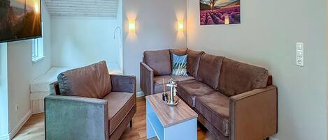 A modern living room with a brown leather sofa, a matching armchair, and a coffee table.
