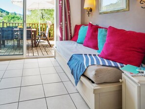 A bedroom with a bed, a nightstand, a lamp, and a view of the outdoors. - 6-person Stunning Duplex Holiday House (Grospierres)