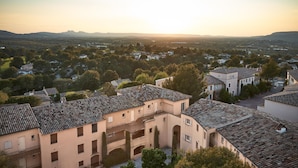 A residential area with traditional architecture, including buildings with tiled roofs and arched doorways. - Chic Riverfront Stay With Terrace (Mallemort)
