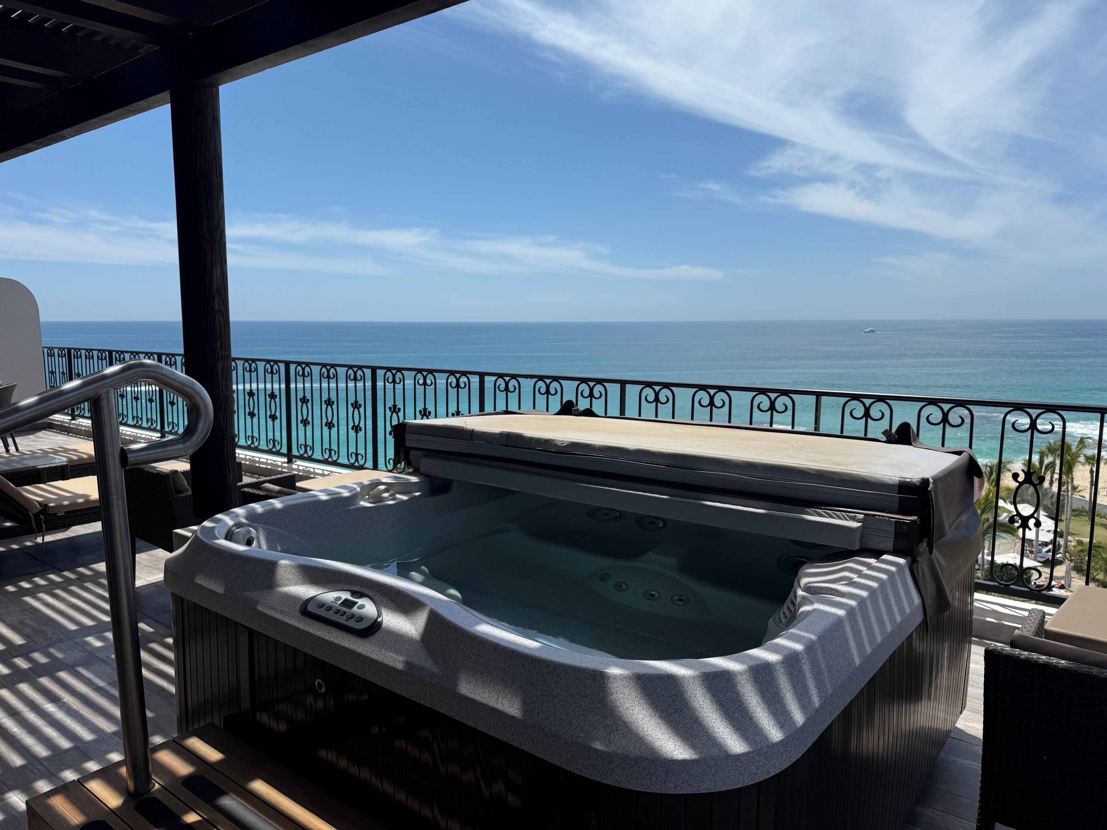 A hot tub on a balcony with a view of the ocean.