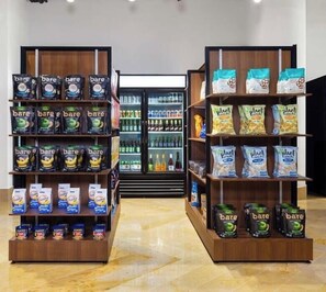 Ein Gang in einem Supermarkt mit Regalen voller Produkte wie 'bare' und 'plant snacks'.
