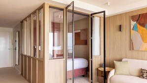 A modern hotel room with a sliding closet, a bed, a sofa, and a painting on the wall. - 1bdr/4p Flat With Stunning sea Views (Antibes)