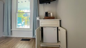 A room with a window, a television mounted on the wall, a small refrigerator, and a coffee maker on a counter. - Walk to Lake & Downtown Chelan! Room #5 (Chelan)