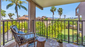 A balcony with wicker furniture, a small table, and a potted plant. - KS4301 Partial Ocean Views, Two King Bedrooms, & Prime Kihei Location (Kihei)
