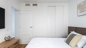 A bedroom with a bed, a wooden dresser, a flat-screen TV, and a door. - Family-friendly Calpe Home With Pool (Calpe)