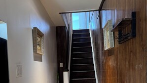 Una escalera con escalones de madera y una pared blanca a un lado.