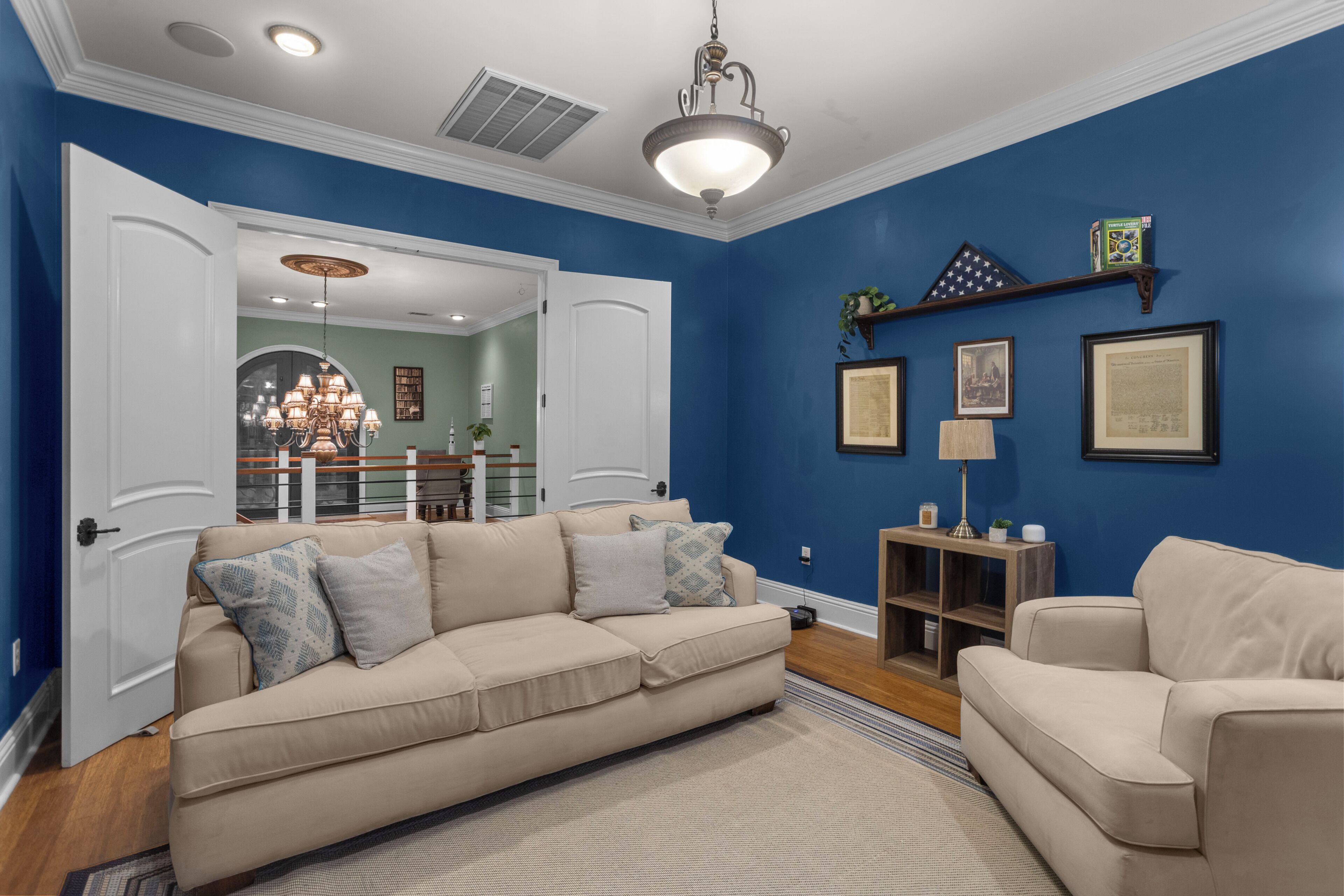 Una sala de estar con un sofá color beige, una mesa de centro y una pared azul de acento.