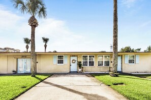 A two-story building with numbered doors, a front entrance, and a small porch area. - Beachside family getaway just steps from the sand. (Jacksonville Beach)