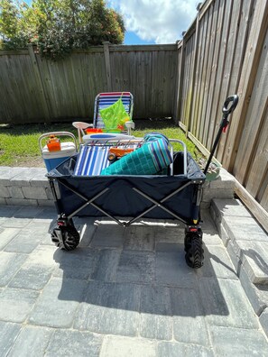A foldable stroller with a storage basket, a small toy car, and a green bag. - Beachside family getaway just steps from the sand. (Jacksonville Beach)