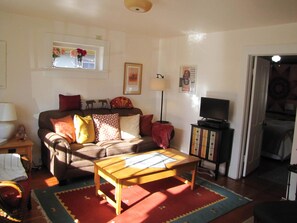 Ein Wohnzimmer mit einer Couch, einem Couchtisch, einem Fernseher und einem Bücherregal.