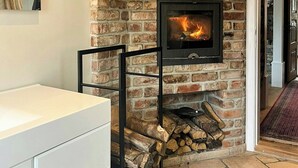 Ein Kamin mit Steinwand, einem weißen Schrank und Holzboden.