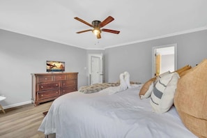 A bedroom with a bed, a ceiling fan, a dresser, a television, and a door. - King Bed - Large Yard - Near UNCC - Concord Mills (Charlotte)
