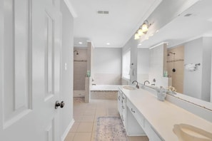 Un baño moderno con lavamanos doble, espejo grande y cabina de ducha.