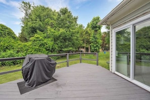 A covered deck with a grill, a glass door, and a view of a wooded area. - King Bed - Large Yard - Near UNCC - Concord Mills (Charlotte)