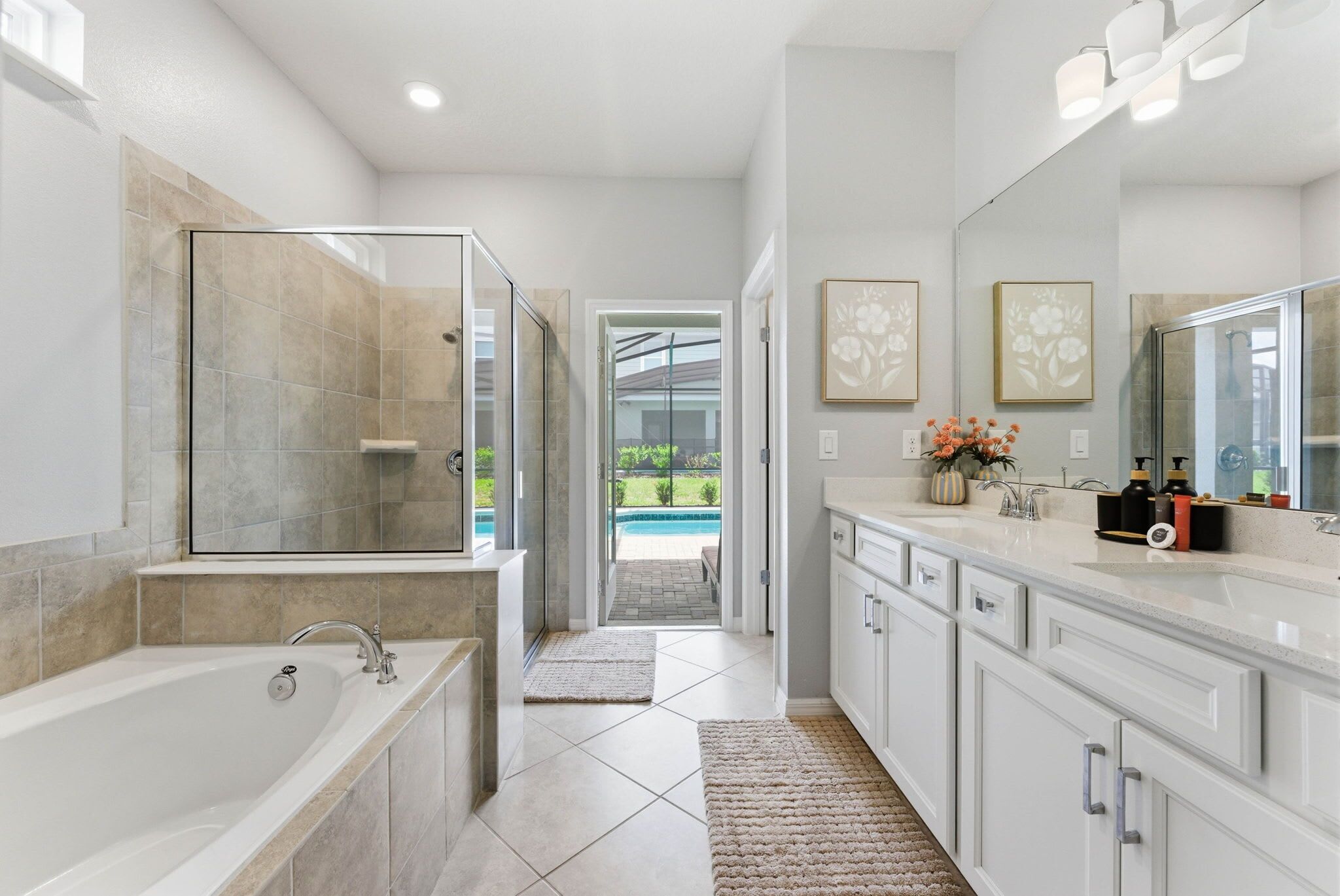 A modern bathroom with a glass-enclosed shower, a bathtub, and a vanity with a large mirror.