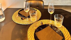 A dining table with a bottle of water, two wine glasses, and a plate with cutlery. - The Secret Rock (La Roche-en-Ardenne)