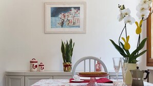 Ett matbord dukat med tallrikar, ett kakfat och en vas med blommor.
