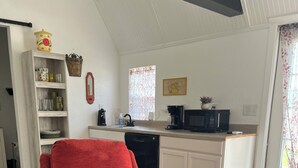 A red armchair and ottoman in a room with a kitchen in the background. -  ROOMY SUNSHINE CABIN IN THE COUNTRY (Claremore)
