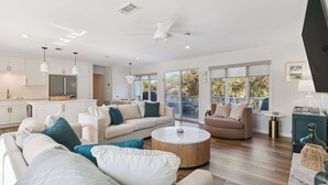 Sala de estar moderna com sofá, mesa de centro e vista para o exterior.