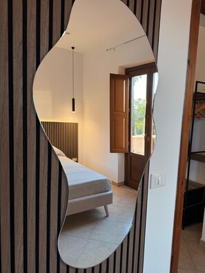 A bedroom with a bed, a hanging light, a door, and a view of the outdoors. - Apartment with terrace for exclusive use 30 m from Palermo Cathedral (Palermo)